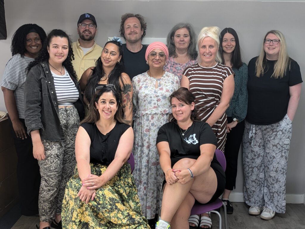 12 members of staff from Leeds Mind's Suicide Bereavement Services posing for a group photo